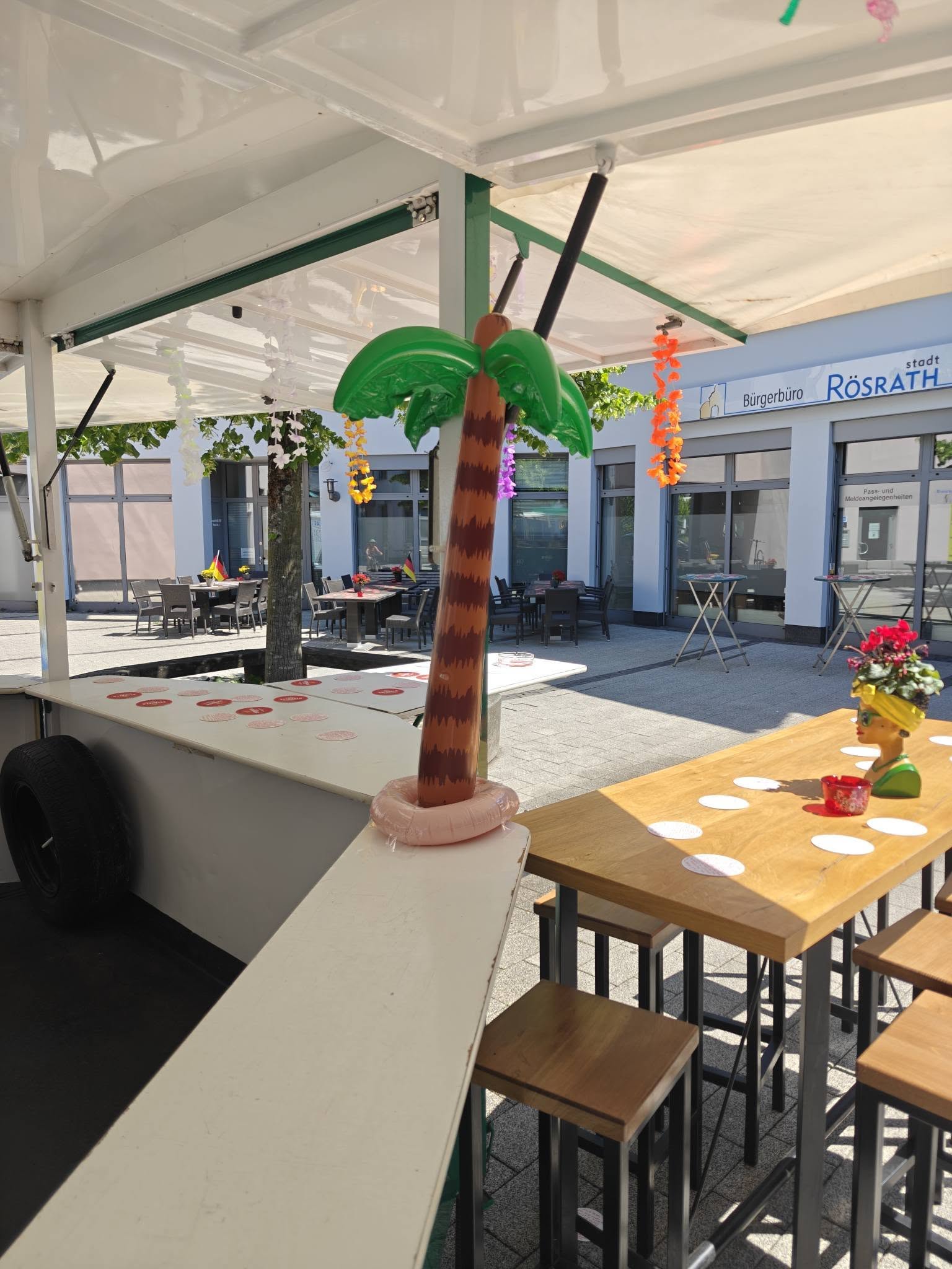 Überdachte Picasso-Terrasse mit Palmen-Dekoration.